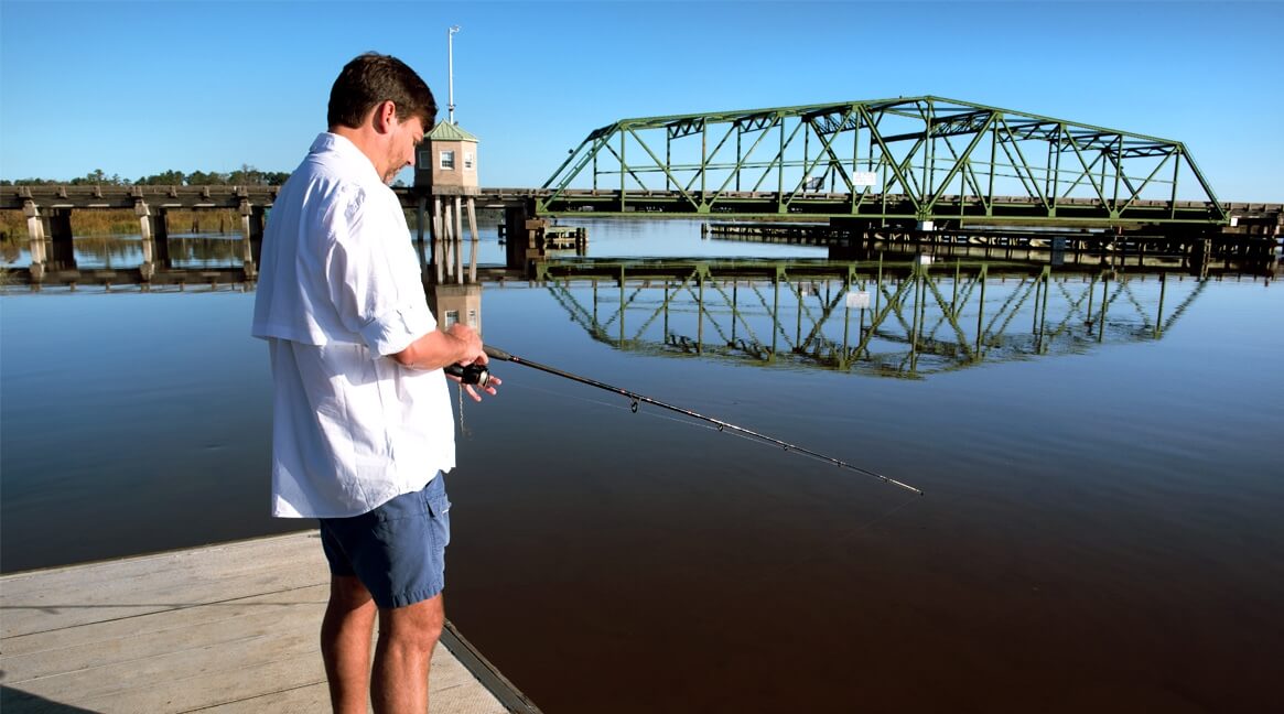 A fisherman enjoys a peaceful day on the dock at Savannah National Wildlife Refuge.